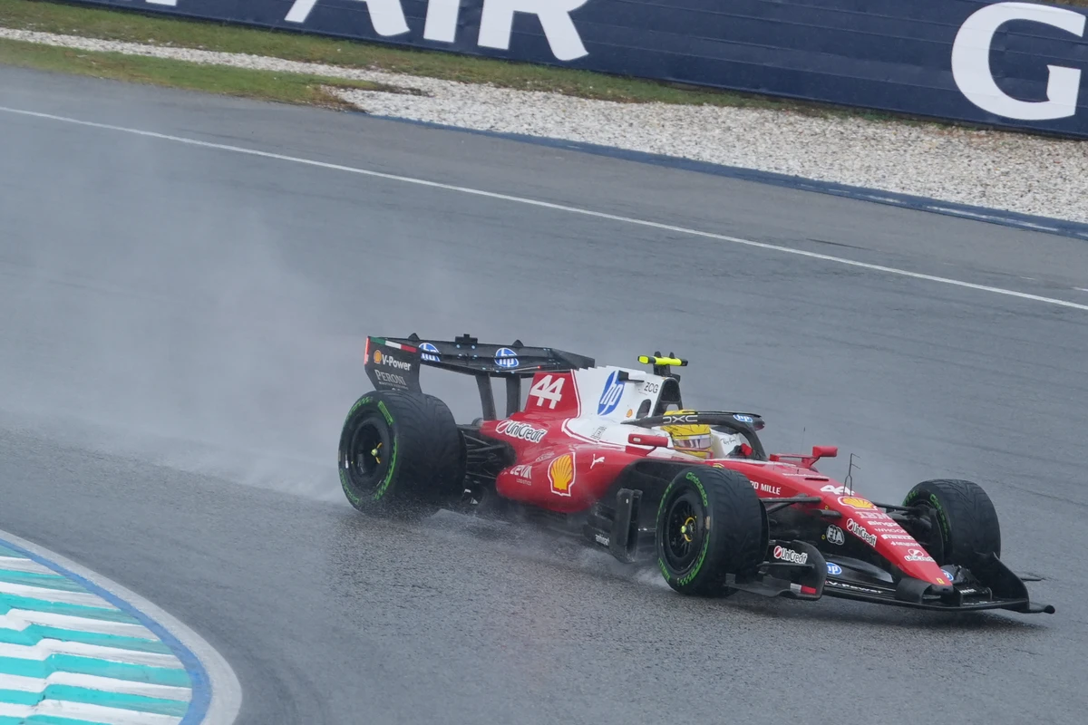 Ferrari number 44 on green-marked tyres throwing spray on a wet Sepang Circuit